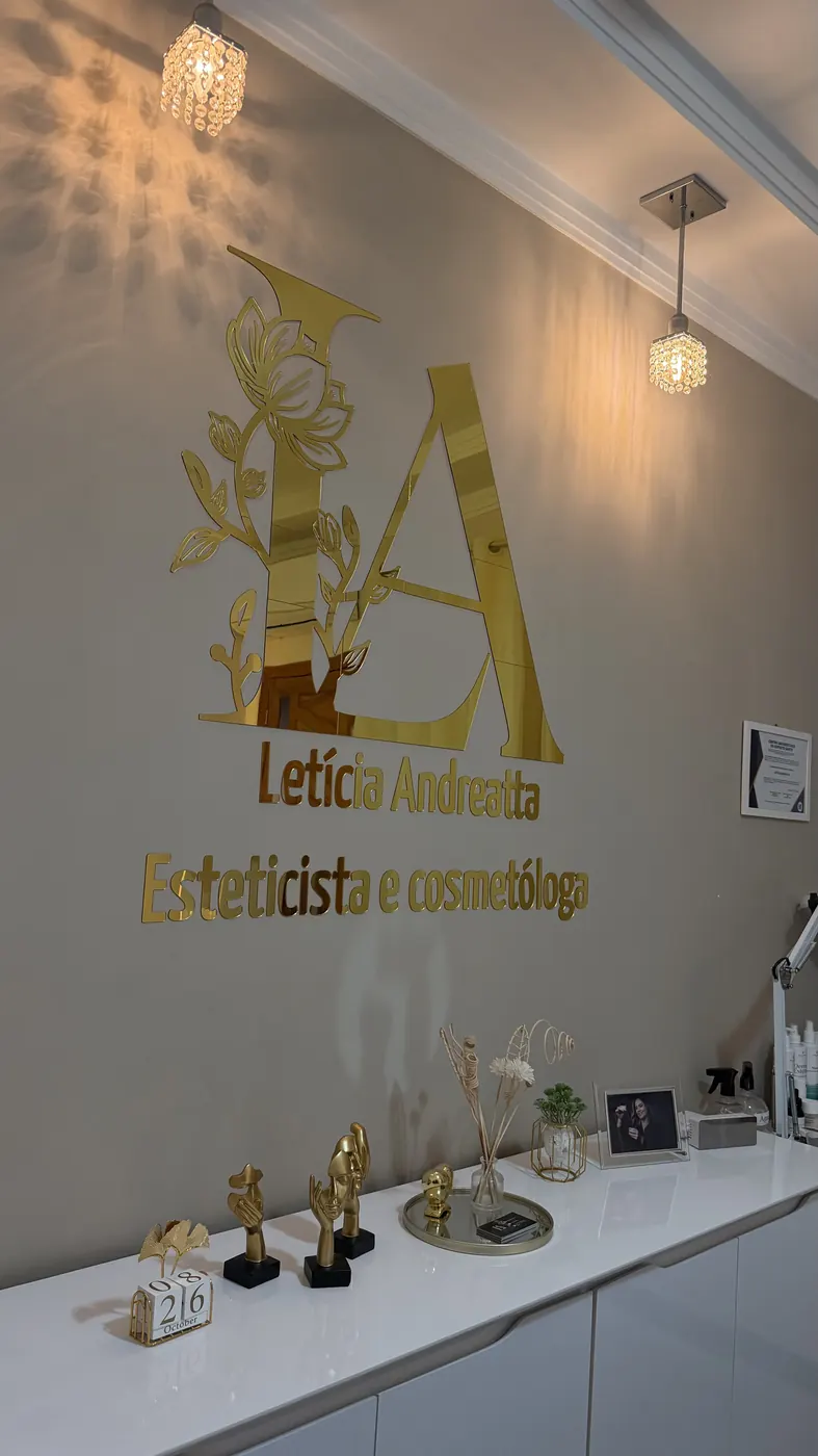 Parede com o logo dourado da Letícia Andreatta