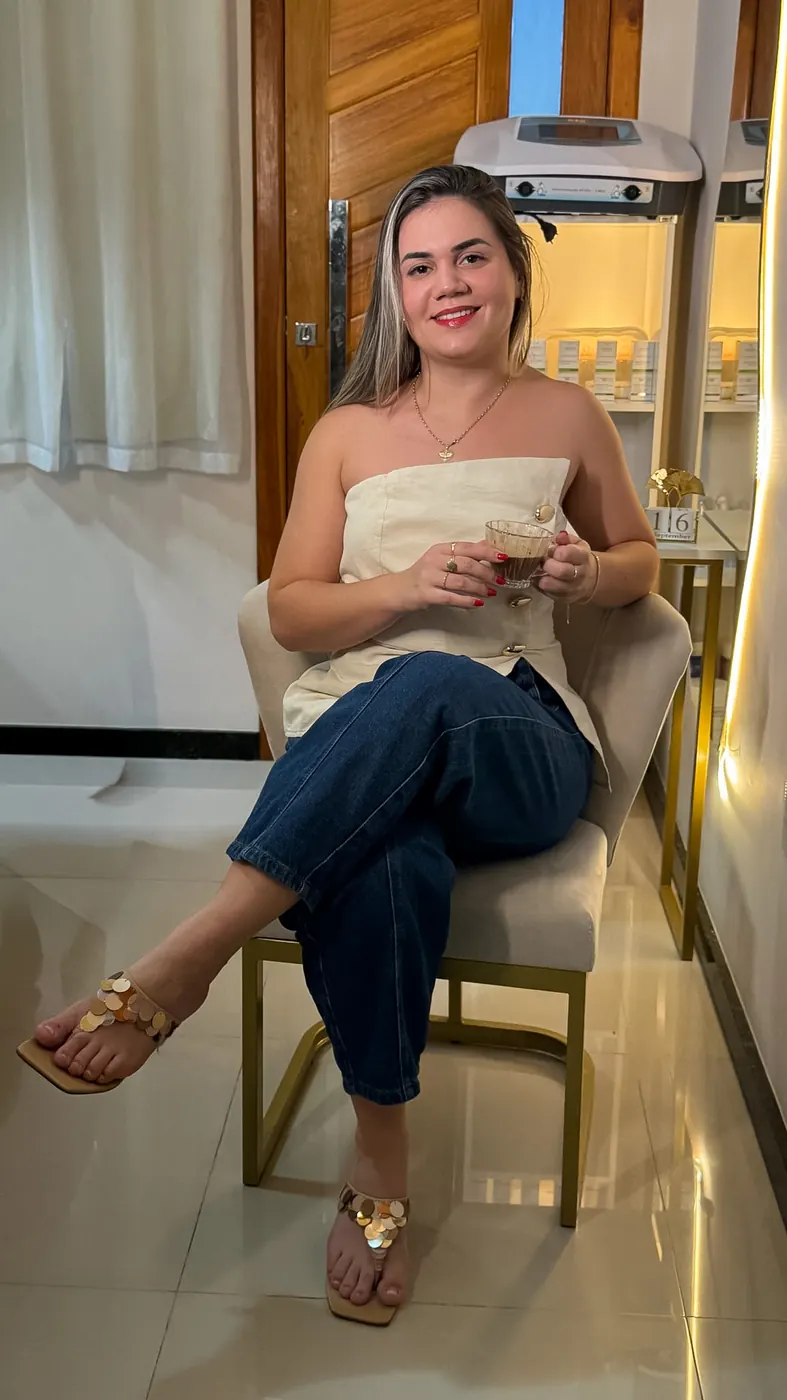 Letícia Andreatta sentada na poltrona do seu espaço de estética